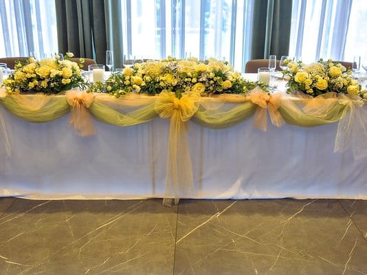 Prezidiul mirilor decorat cu aranjamente florale albe și tul, la o nuntă în Cluj